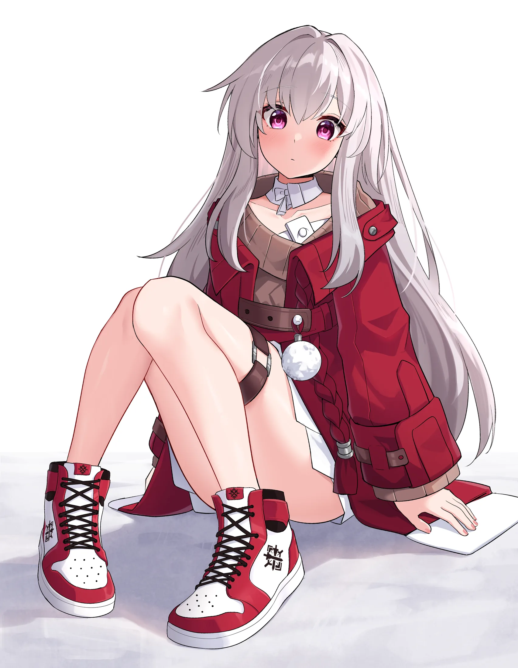 Clara in a red coat sitting in the snow wearing red and white sneakers